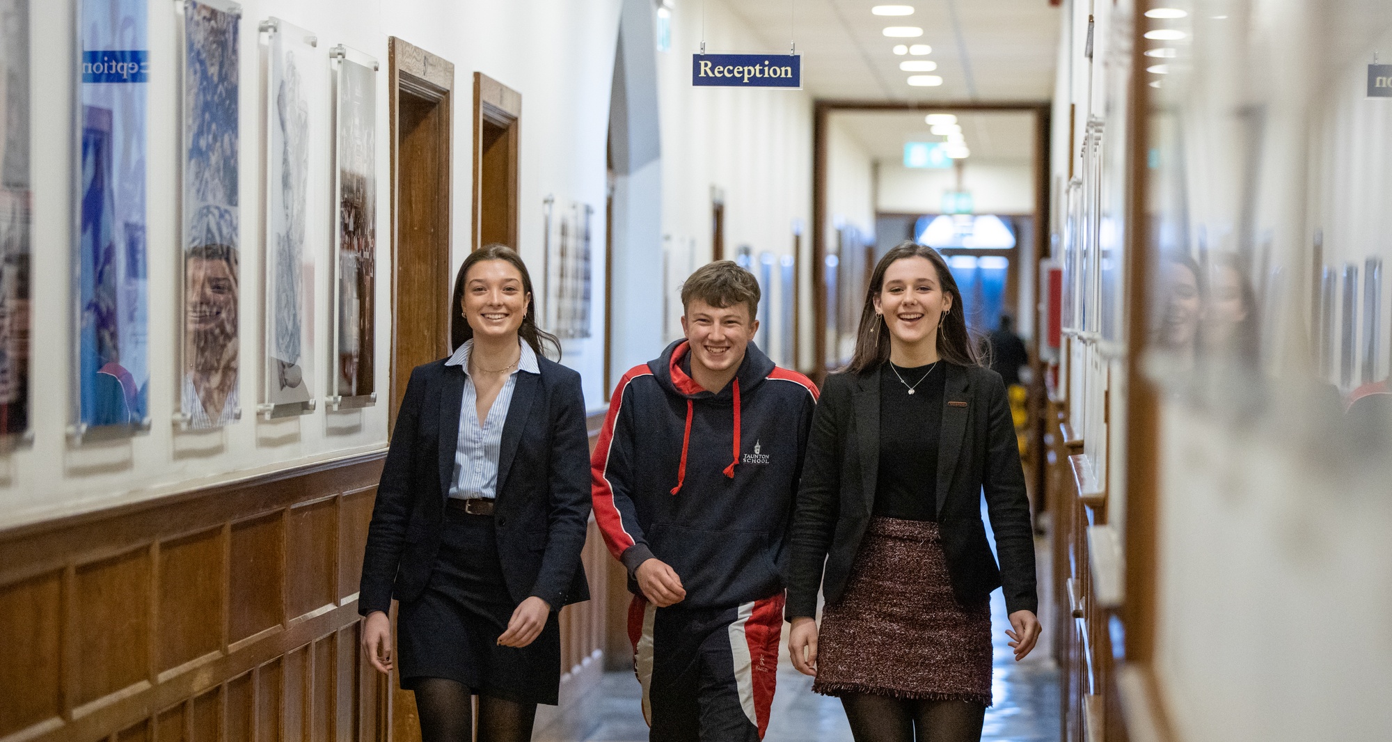 Three students walking through the corridor