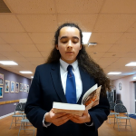 student preparing for the debating competition by reading a study book