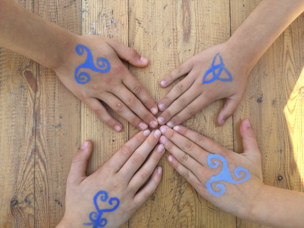 Different blue celtic symbols on hands