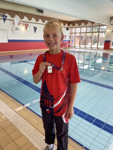 Boy with medal next to a swimming pool