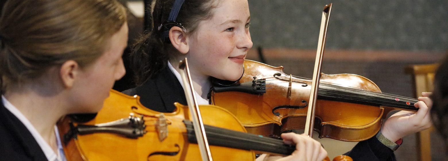 two prep school students playing violin