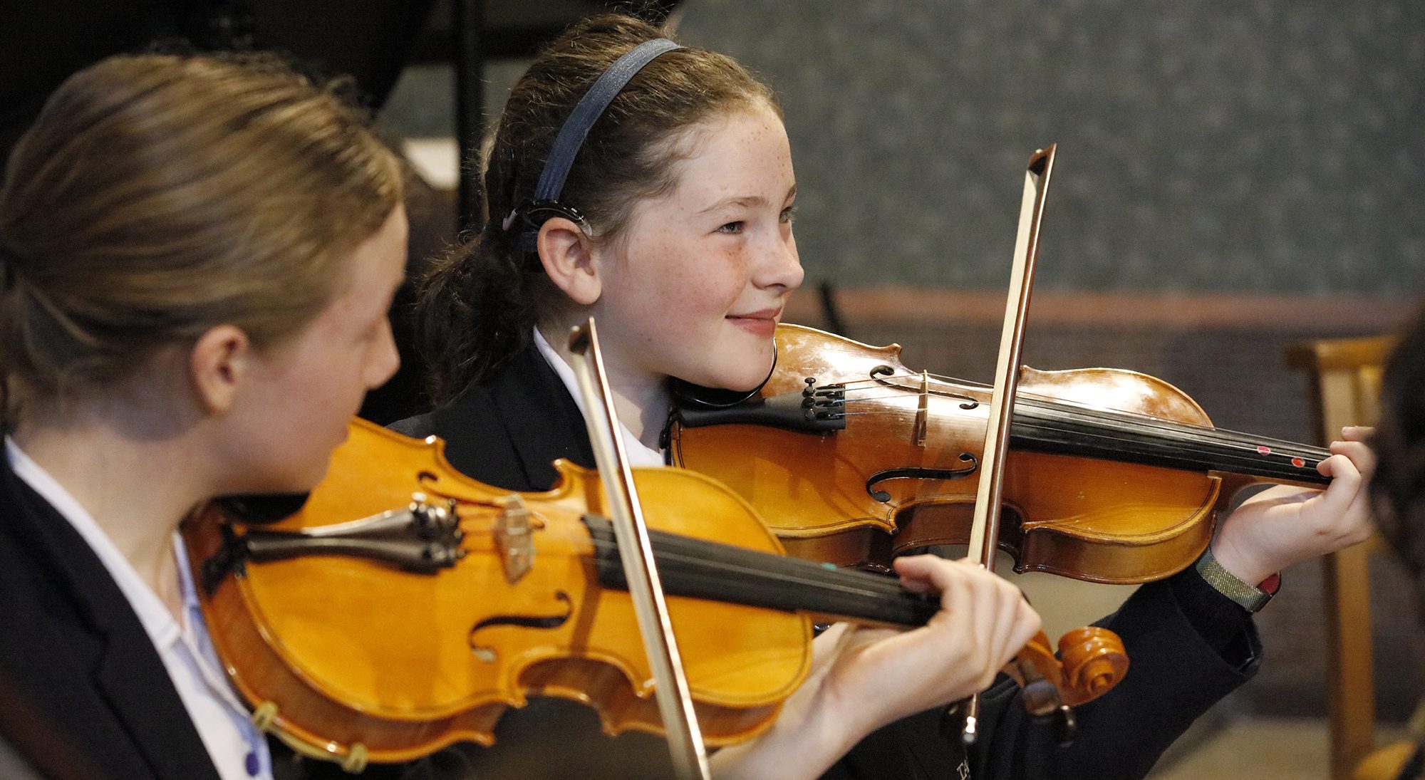 two prep school students playing violin